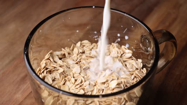 Milk flowing down on oat in bowl