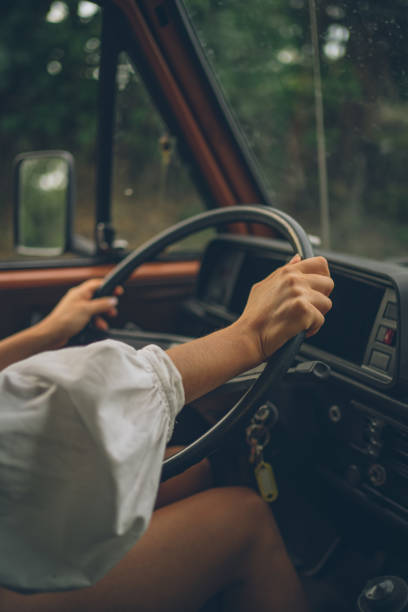 istock Young woman drives van down forested road 1353388278