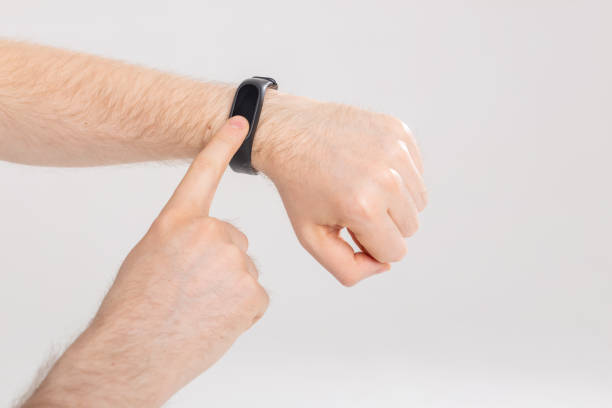 istock Fitness and technology concept - Activity tracker on a male wrist on white background 1353388350