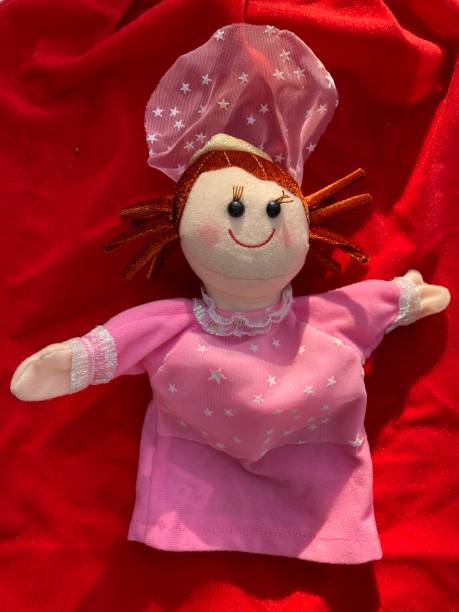 istock Top view of a cook puppet toy on a red blanket. 1353389176