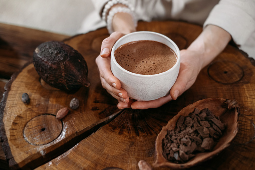 Persona que da cacao ceremonial en taza. bebida de chocolate vista superior photo