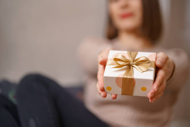 istock Woman hands holding a ghift box 1353389445