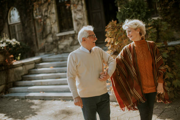 istock Senior couple walking in autumn park 1353390079
