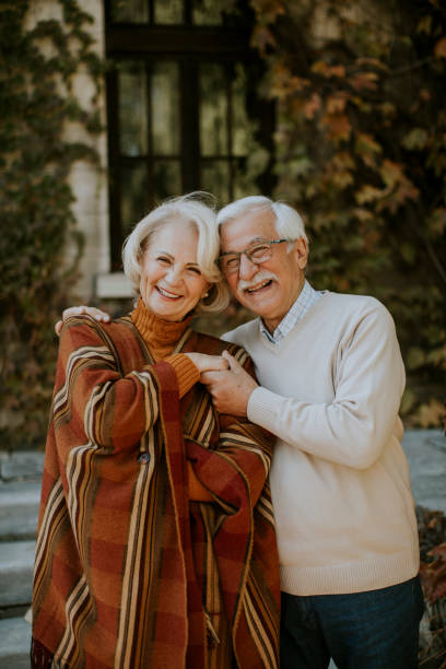 istock Senior couple embracing in autumn park 1353390109