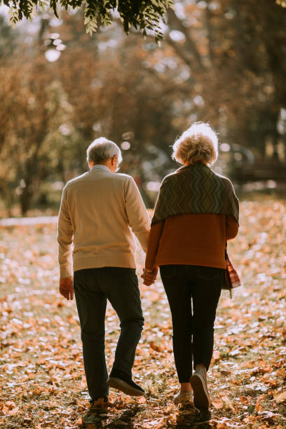 istock Senior couple walking in autumn park 1353390123