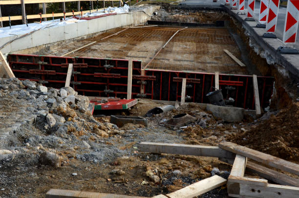 istock Construction work for the reconstruction of a road bridge. wires and nets for concrete reinforcement before applying concrete to the formwork. safety plastic marking the edge of the construction site 1353394565