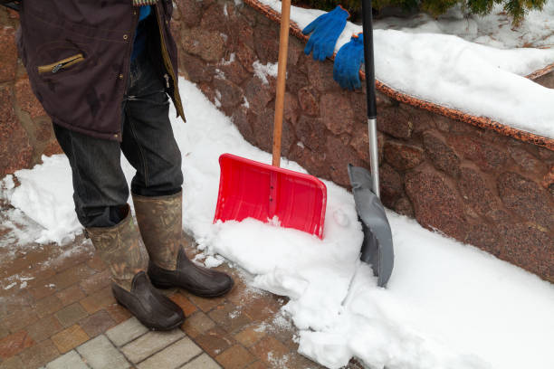 istock Two plastic snow shovels stand in front of fence 1353395921