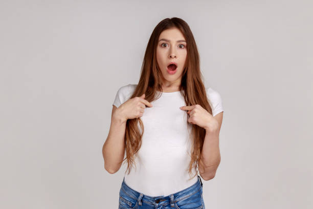 istock Amazed woman pointing herself and looking with shocked expression, screaming from sudden crazy news. 1353397259
