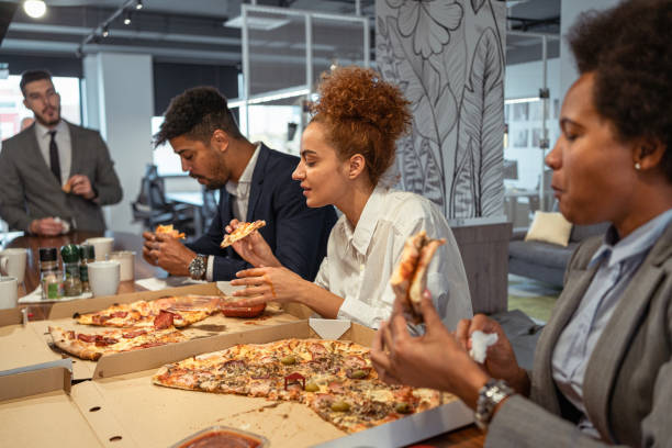 istock For the lunch break, multiracial business people eating a pizza 1353397486