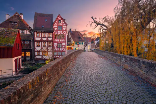 Cityscape image of old town street of Ulm, Germany with traditional Bavarian architecture at autumn sunset.