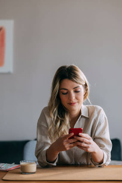 istock Smiling Businesswoman Using Mobile Phone at Home 1353399616