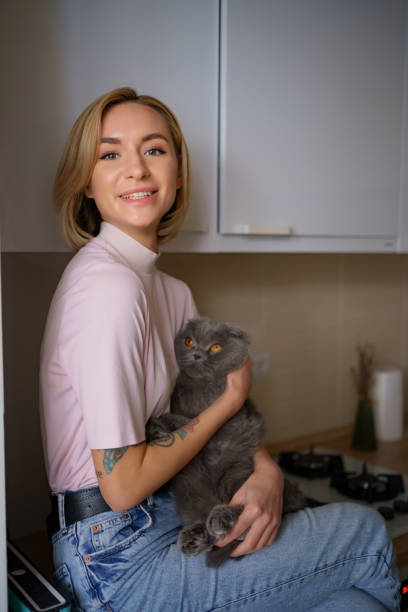 istock Woman siting on kitchen hugging a cat 1353399761