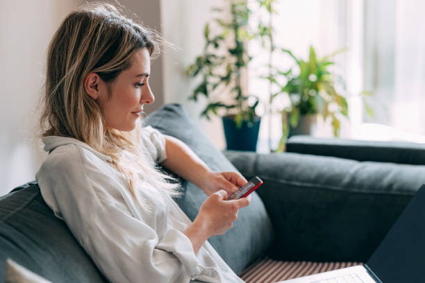 istock Beautiful Woman Using Mobile Phone at Home 1353399789