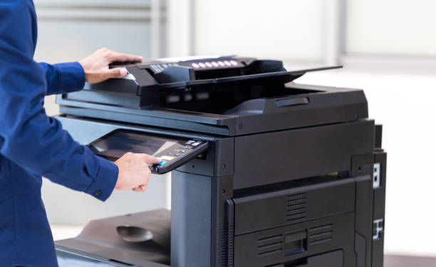 Businessman press button on panel of printer photocopier  network , Working on photocopies in the office concept , printer is office worker tool equipment for scanning and copy paper. stock photo
