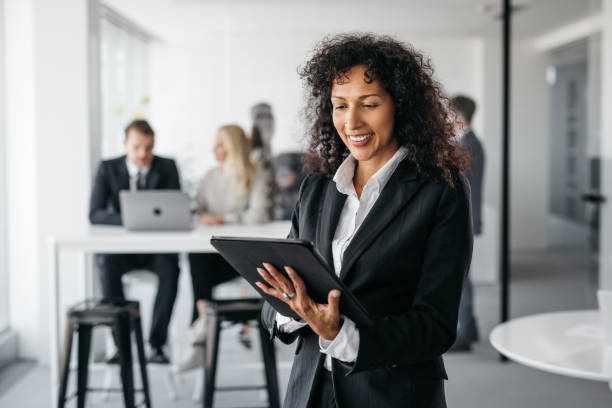 istock Happy business woman working on her tablet 1353400656