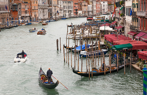 Venice, Italy: Many gondolas near small restaurants past water canals of historical area on 7 October 2021. Ancient italian city and lagoon are UNESCO World Heritage Sites