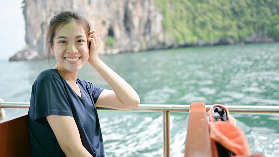 Young asian woman travel tropical beach sea by public transport on the ferry boat at trang and krabi thailand beach sea travel