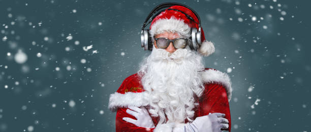 cool santa claus écoute de la musique dans des écouteurs - santa claus audio photos et images de collection