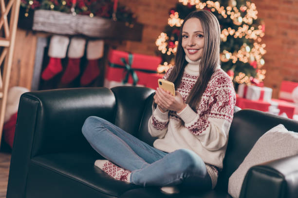 istock Photo of adorable pretty young lady dressed print pullover typing modern device new year greetings smiling indoors room home house 1353403164