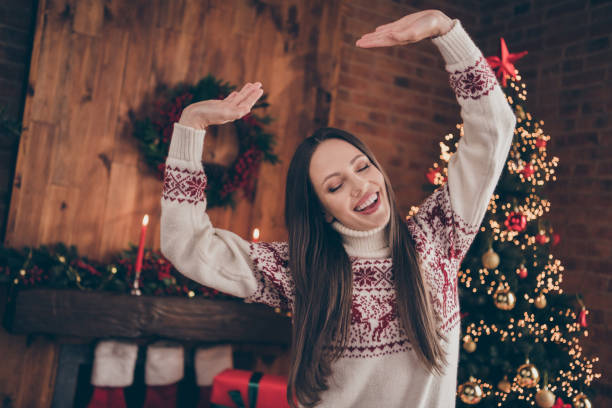 istock Photo of charming funny young lady dressed print pullover celebrating christmas dancing smiling indoors room home house 1353403465