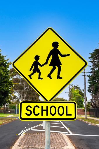 Children crossing road sign next to the school.