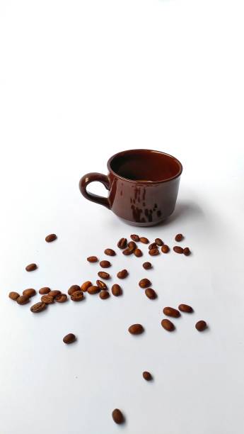 istock A cup of coffee, and coffee beans scattered on a perfect white background. 1353404928
