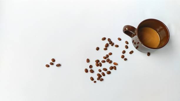 istock A cup of coffee, and coffee beans scattered on a perfect white background. 1353406642