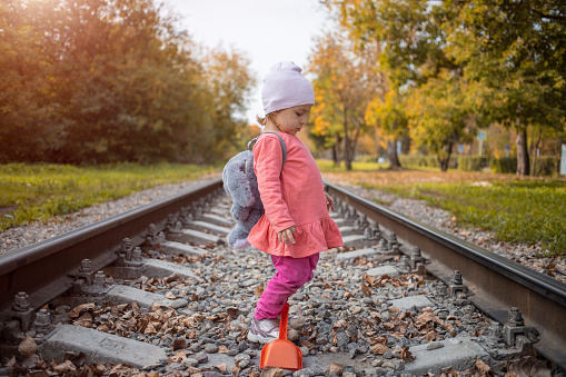 child walk in dangerous on railroad alone autumn day