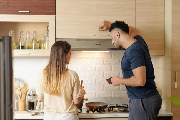 istock Curious Man Looking at Cooking Wife 1353408609