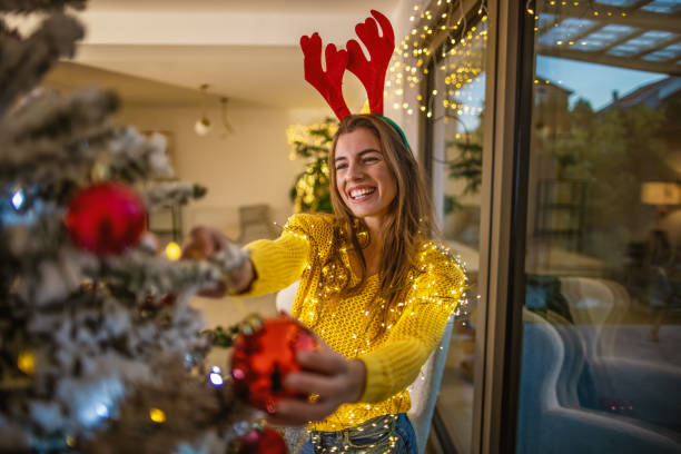 istock Young woman decorating a Christmas tree 1353408924