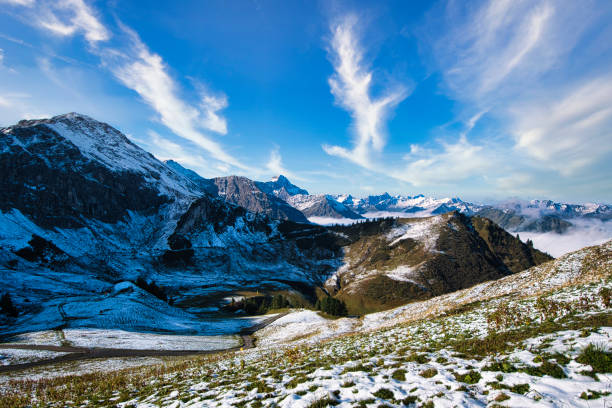 Long distance photograph of snowy mountain peaks with an overcast cloudy sky during winter