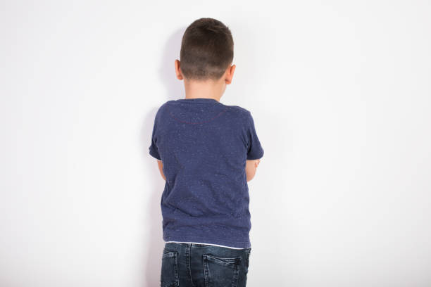 angry boy  facing the wall - displeased child abandoned child abuse imagens e fotografias de stock