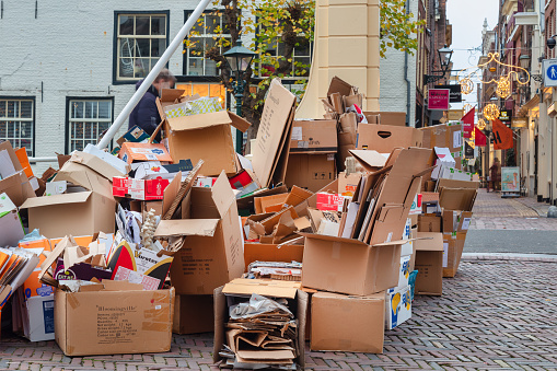 Alkmaar, The Netherlands - November 10, 2021: Stores have collected cardboard waste boxes for weekly pickup in the ancient city center of Alkmaar, The Nertherlands