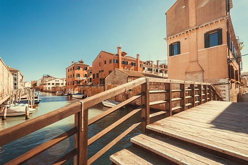 Bright morning over water canals, bridges and brick houses, bridges in historical area Cannaregio