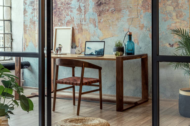 istock Stylish loft interior design. Open space. Home decor. Wooden table, desk with design accessories. Template. 1353416116
