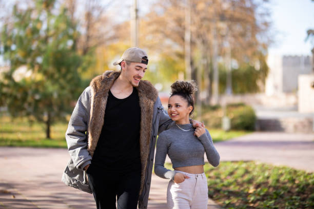 istock Young couple walking in public park 1353417171