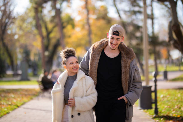 istock Young couple walking in public park 1353417672