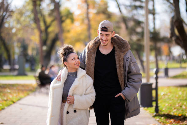 istock Young couple walking in public park 1353417699