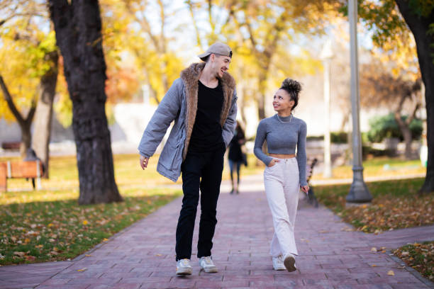 istock Young couple walking in public park 1353417752