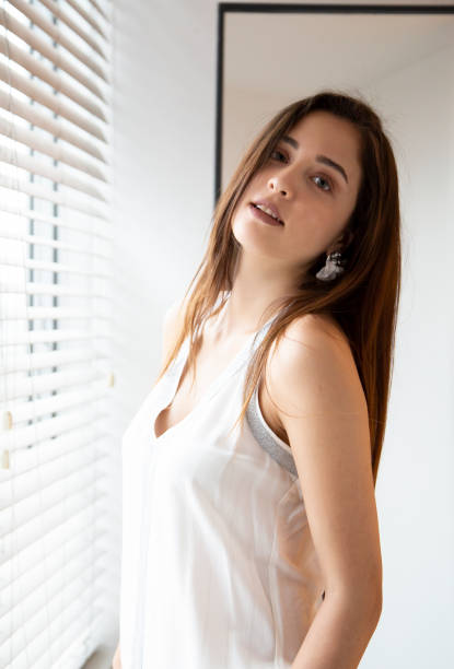 istock Young Girl Standing in Front of Window 1353418990