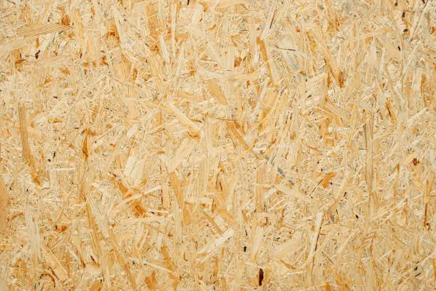 Photo of Chipboard texture background. Chipboard, particle board, engineered sheet wood made from small wood chippings.