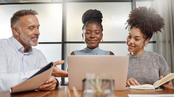 istock Shot of a group of businesspeople using a laptop at work 1353419700