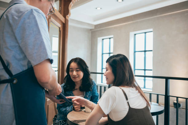 istock cafe owner using a digital tablet to show the menu to a custom 1353423288
