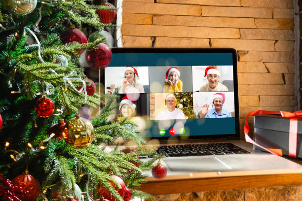 istock Virtual Christmas day house party. video conferencing Young man having video call via computer in the home office Online team gift opening conference calling. 1353423733