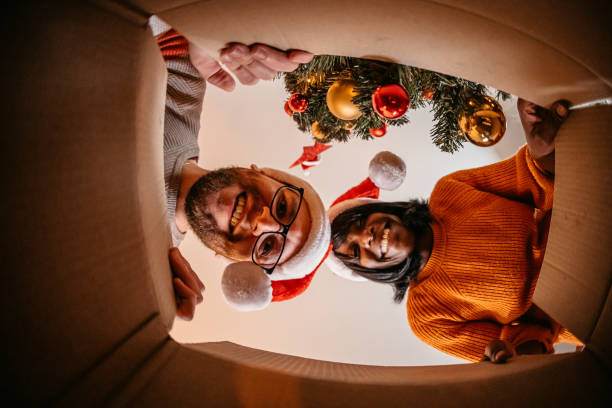 istock Multiethnic couple unpacking Christmas present 1353424178