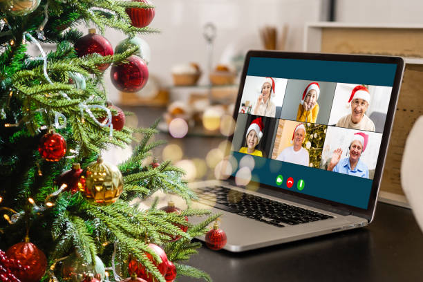 istock video call with happy diverse children on laptop computer in his workshop. Self-isolation and virtual online celebration at home concept. Christmas 1353424230