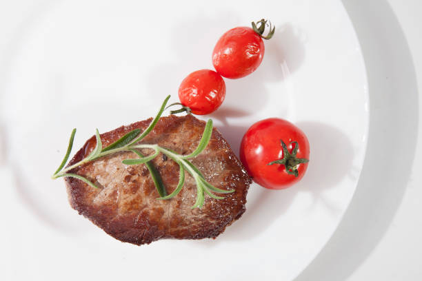Rump steak grilling at high heat in cooking pan, close-up