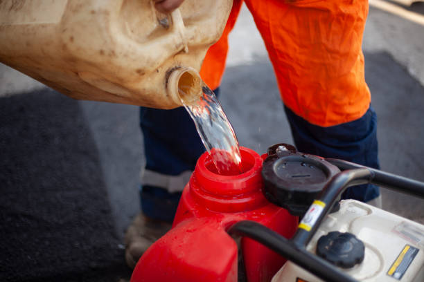 Canister of gasoline. Diesel engine refueling. Worker pours fuel into tank. stock photo