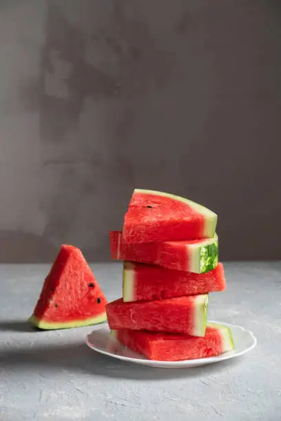 Photo of Sliced watermelon in a plate on a gray background