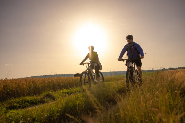 istock Mature couple riding bicycle on slope 1353428316